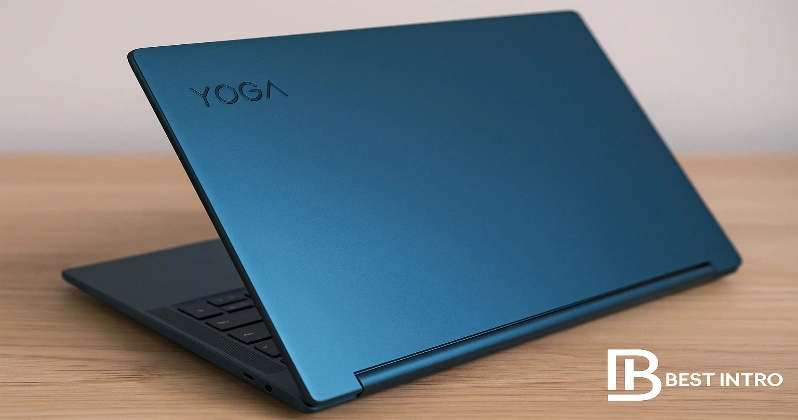 لپ‌تاپ لنوو Yoga 9i مدل Aura Edition با رنگ آبی کیهانی روی میز چوبی، همراه با لوگوی ITrends در گوشه تصویر