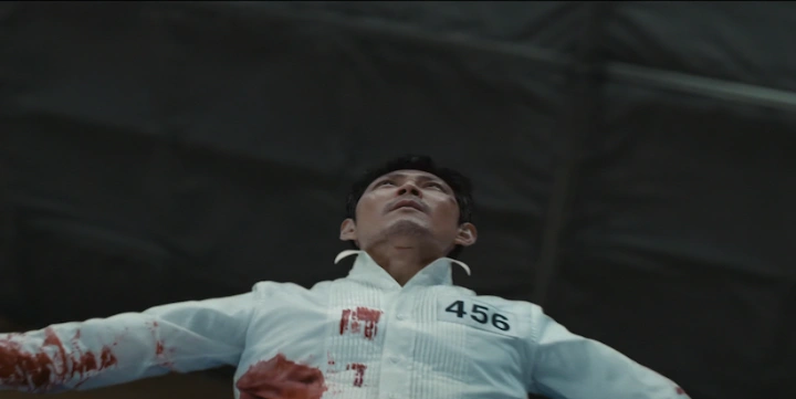 لی جونگ‌جه در نقش گی‌هون در لحظه‌ای تلخ از فصل سوم Squid Game؛ در لباس سفید و خون‌آلود، آماده برای فداکاری نهایی