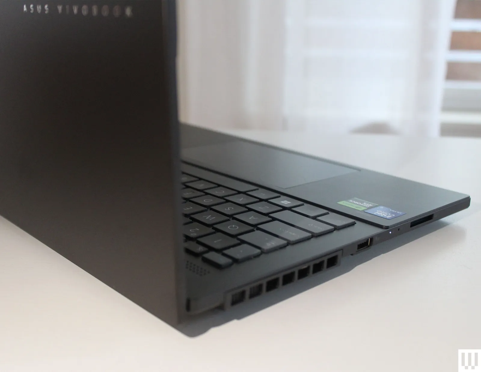 نمای سمت چپ و پشت لپ‌تاپ Asus Vivobook Pro 15 با خروجی هوا، پورت USB-A و شیار کارت‌خوان SD