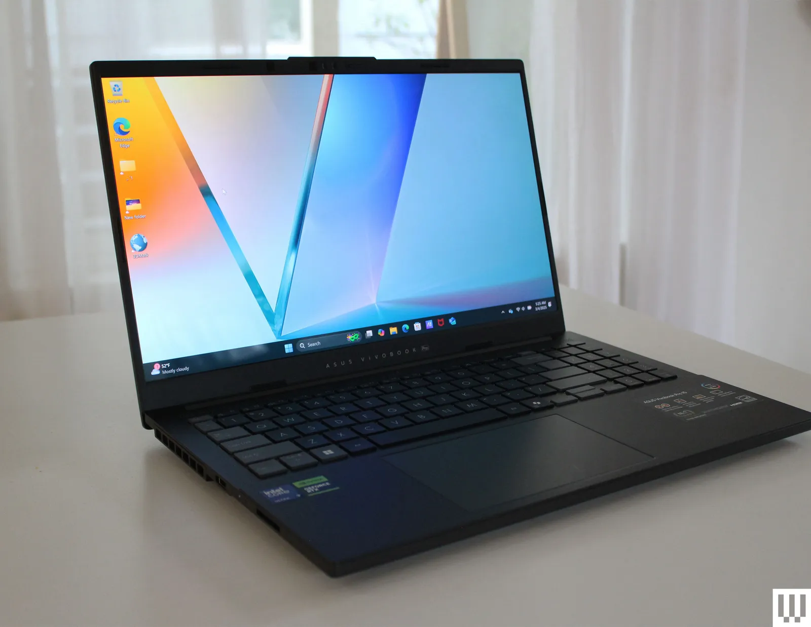 نمای کناری لپ‌تاپ Asus Vivobook Pro 15 با نمایشگر OLED روشن و طراحی ساده