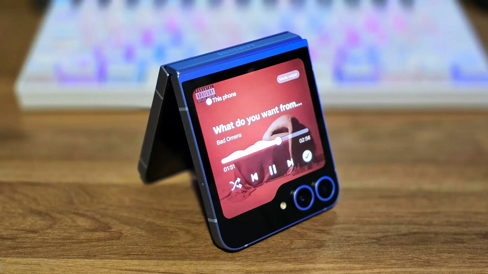 گلکسی Z Flip7 در حالت نیمه‌باز، با صفحه‌نمایش پشتی فعال و در حال پخش موسیقی